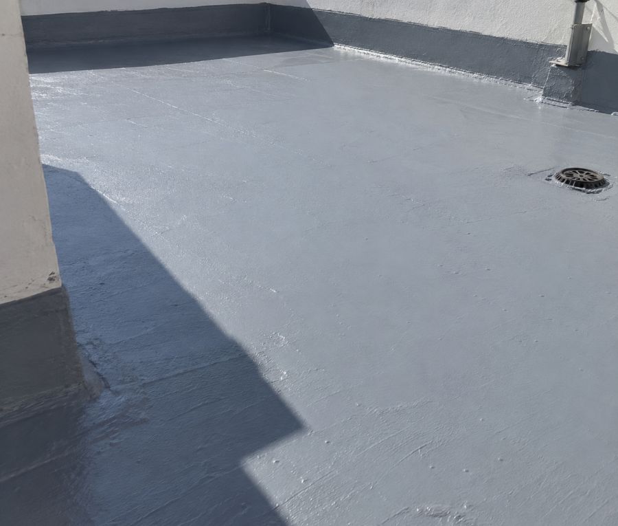 Cubierta plana impermeabilizada en gris con el peto rematado y el sumidero sellado