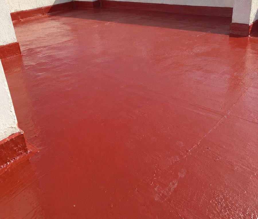 Terraza de ático impermeabilizada en rojo, con los rodapiés y los encuentros sellados